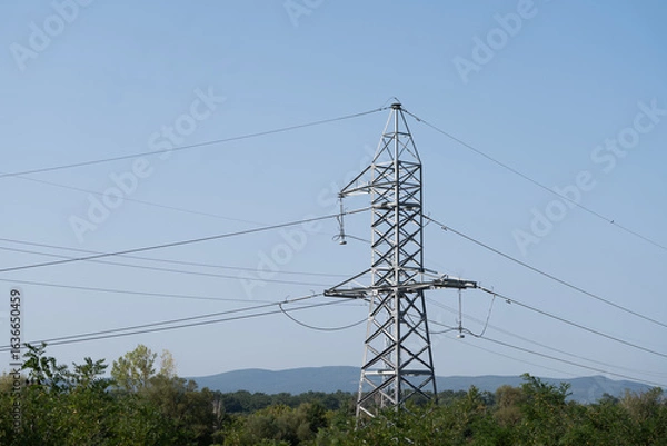 Fototapeta High-voltage power line tower standing against the sky, transmitting electricity across long distances.