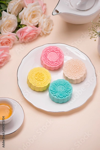 Fototapeta Sweet color of snow skin mooncake. Traditional mid autumn festival foods with tea on table setting.
