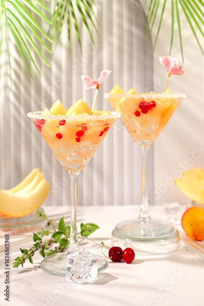 Fototapeta Melon alcoholic cocktail with mint. Martini and royal sangria with melon slices, ice, mint and currants. Summer party concept, advertising for a bar or cafe, detox diet