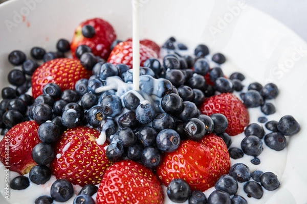 Fototapeta Strawberries, blueberries and milk in a white bowl