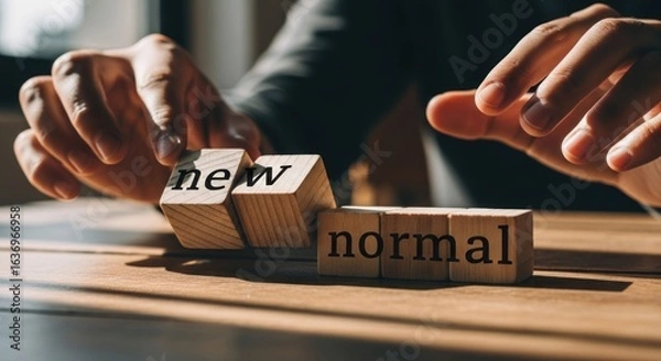 Fototapeta Hands arranging wooden blocks with the words "new" and "normal