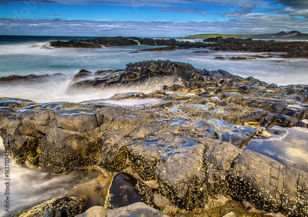Fototapeta Long time exposure of waves around rocks at the Wild Coast at the Indian Ocean in South Africa