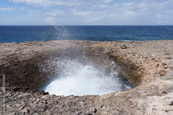 Fototapeta 
Watamula Hole rock formation on the seashore in Curaçao, where the Caribbean waves crash in with force, creating a unique natural spectacle under the blue sky