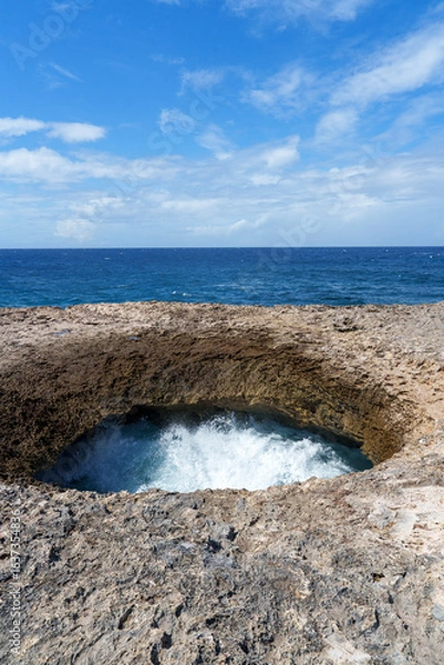 Obraz 
Watamula Hole rock formation on the seashore in Curaçao, where the Caribbean waves crash in with force, creating a unique natural spectacle under the blue sky