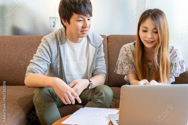 Obraz リビングルームでオンライン通話している日本人の男女