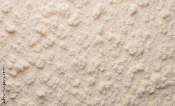 Fototapeta Close-up of textured white substance resembling fine sand or powdered sugar.