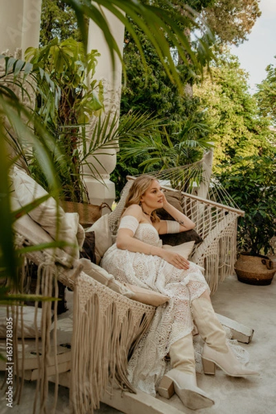 Obraz  Beautiful slim blonde poses in boho wedding dresses and an embroidered corset on a summer terrace.