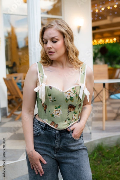 Obraz  Beautiful slim blonde poses in boho wedding dresses and an embroidered corset on a summer terrace.