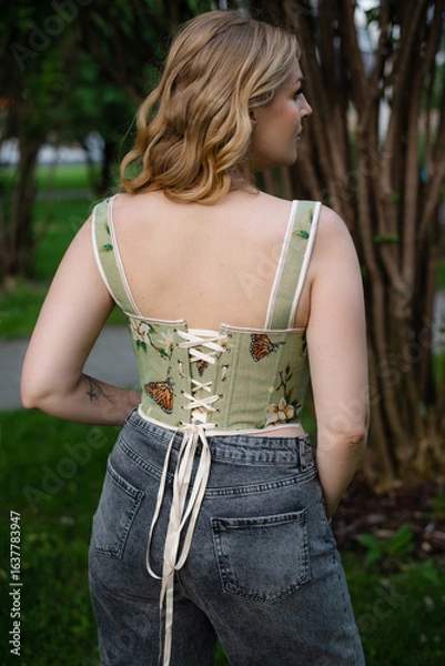 Obraz  Beautiful slim blonde poses in boho wedding dresses and an embroidered corset on a summer terrace.