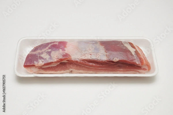 Fototapeta 흰색 배경 위에 스티로폼 트레이에 담긴 생삼겹살 조각