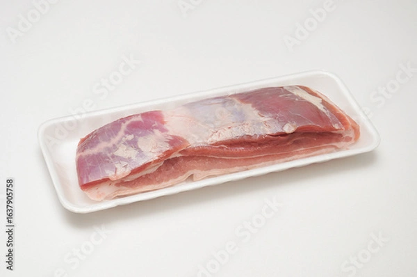 Obraz 흰색 배경 위에 스티로폼 트레이에 담긴 생삼겹살 조각