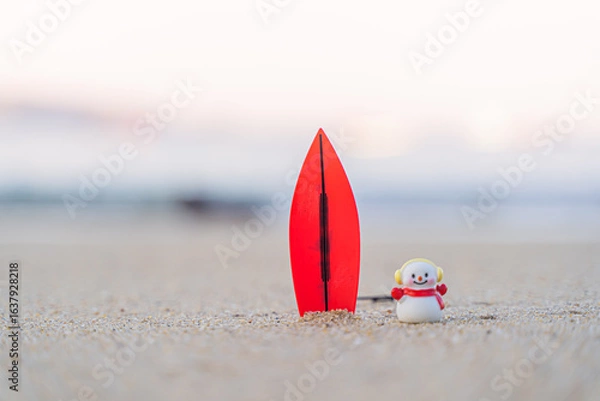 Fototapeta Sandy Christmas Snowman is watching the waves, standing on beautiful beach with a surf board - horizontal version in Patong Beach, Phuket, Thailand