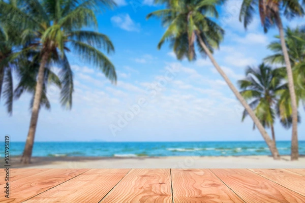 Obraz Wooden table in front of abstract blurred sea & coconut tree background. For present your products. Summer Concept