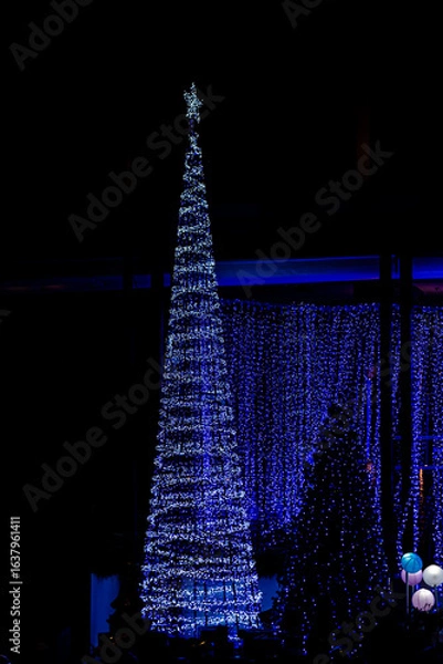 Fototapeta Christmas and New Year interior decoration with background, pine tree decorated with beautiful garlands of lights.