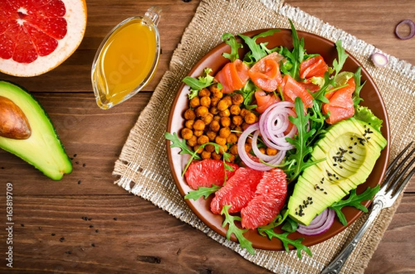 Fototapeta Healthy salad bowl with salmon, grapefruit, spicy chickpeas, avocado, red onion and arugula