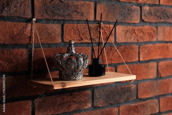 Fototapeta Wooden shelf with reed diffuser and home decor on brick wall
