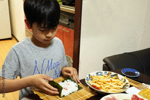 Obraz 手巻き寿司の夕食のご飯を作る小学生の子供