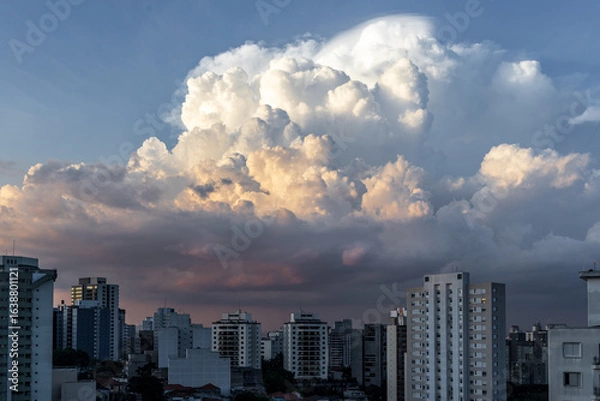 Fototapeta dramatic sky with orange tones in a sunset with buildings in sao paulo with dramatic clouds in the sky