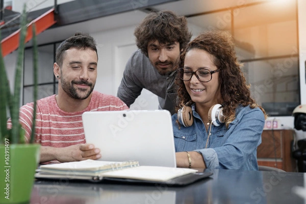 Obraz Young entrepreneurs working on digital tablet