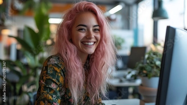 Fototapeta Candid, inclusive creative office female employee with pastel pink hair laughing while working at a computer in a bright LGBTQ+ friendly agency workplace, Generative AI