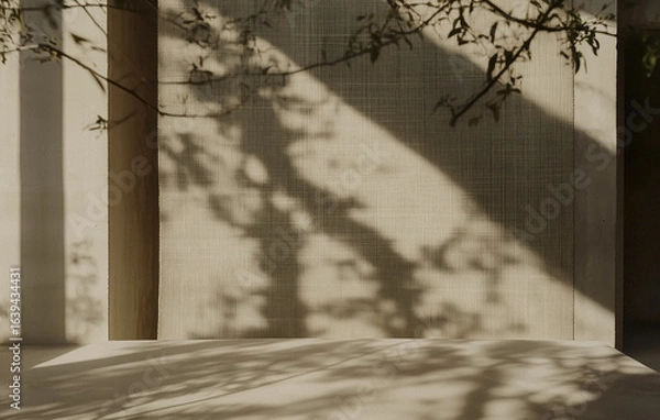 Fototapeta Shadows of tree branches create intricate pattern on textured beige wall, evoking serene and natural ambiance. play of light and shadow adds depth and interest to minimalist scene