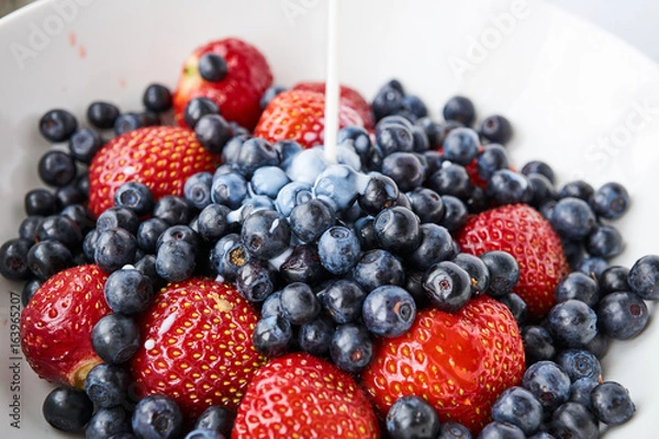 Obraz Strawberries, blueberries and milk in a white bowl