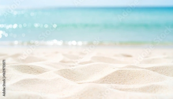 Fototapeta A serene beach scene featuring soft, golden sand and glistening turquoise water, evoking a sense of calm and relaxation.