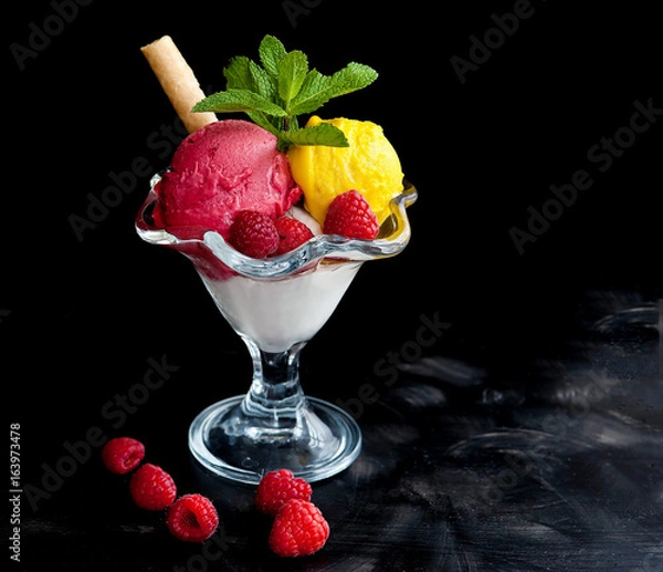 Fototapeta Ice cream in a glass cube with raspberries and mango