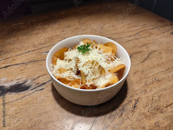 Obraz Sweet Potato Chips - Sliced with crispy sweet potato chips served with white bowl over wooden table