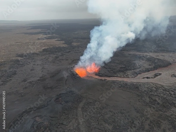 Obraz 4K Aerial Drone Footage of an Active Volcanic Eruption with Lava Flow and Smoke over a Rugged Lava Field