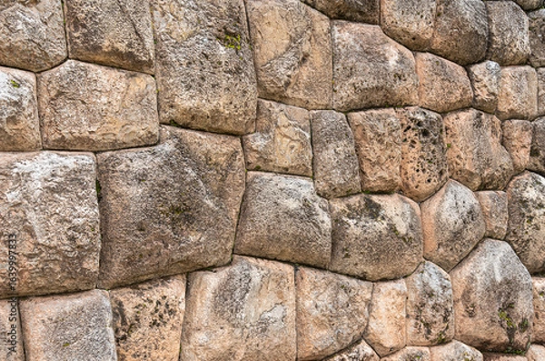 Fototapeta A detailed view of the precisely fitted stones forming an ancient Inca wall at the archaeological site of Chinchero, Peru.