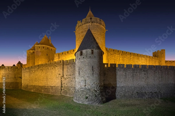 Fototapeta CARCASSONNE,FRANCE - - The Comtal Chateau from XII.Century and outer ramparts in Carcassonne Old City at dusk. Carcassonne is a fortified French town in the Aude department.