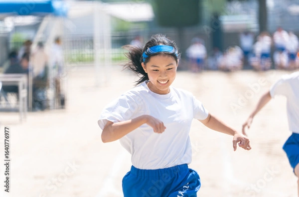 Fototapeta 中学校の体育祭で100m走を走る女子生徒