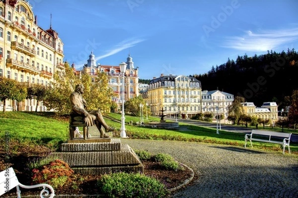Fototapeta Panorama view of Goethe square with statue, hotel buildings and fountain in the spa park of the town Marianske Lazne (Marienbad) - Czech Republic (region Karlovy Vary)