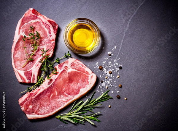 Fototapeta Two raw veal chops with ingredients