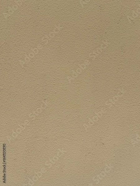 Fototapeta Vertical beige plaster wall with coarse texture. Architectural surface detail, construction material close-up. Old grungy decorative background for design or copy space