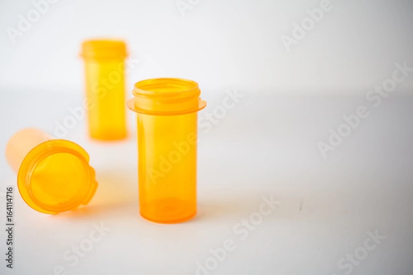 Fototapeta Shallow depth of field on 3 prescription vials on white, suitable for  representing healthcare or substance abuse