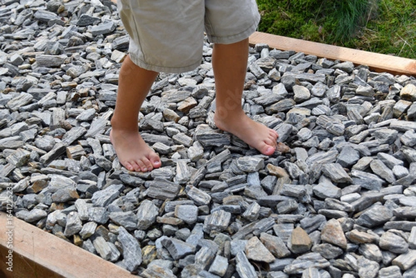 Fototapeta Boy’s bare feet walking on a sensory path in a pine forest