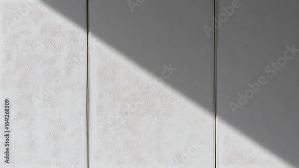 Fototapeta Textured concrete wall with neutral tones and subtle shadows from directional lighting.