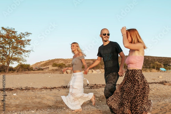 Fototapeta Happy couple running on the beach at sunset in Potos, Thassos