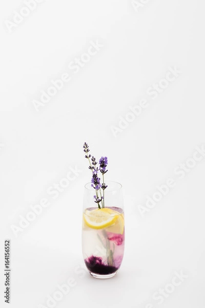 Fototapeta refreshing homemade lemonade with lavender and lemon pieces in glass isolated on white