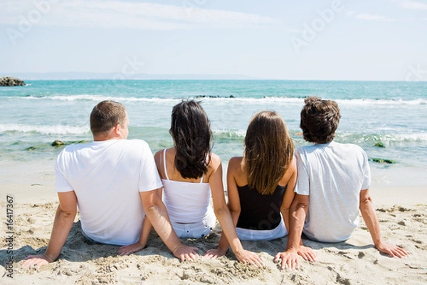 Obraz Widok z tyłu przyjaciół siedzących na plaży