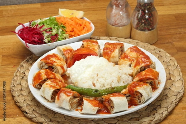 Fototapeta Chicken Doner wrapped in thin lavash bread with beyti sauce, butter and seasonal salad