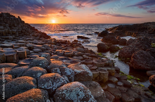 Fototapeta zachód słońca nad bazaltowymi kolumnami Grobla Olbrzyma znana jako miejsce światowego dziedzictwa UNESCO, hrabstwo Antrim, Irlandia Północna