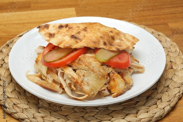 Fototapeta Chicken doner sandwich in gobit bread with tomato and cucumber pickles