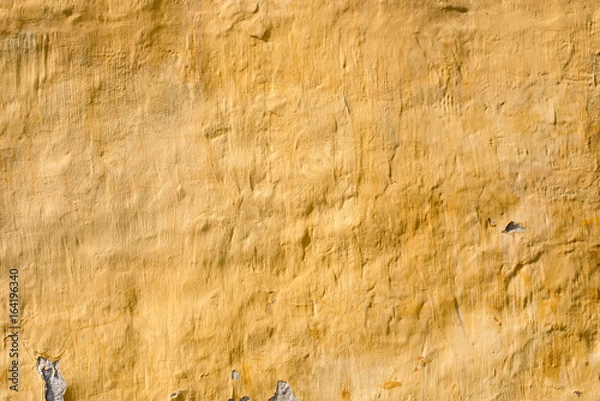 Fototapeta Old brick wall with old yellow plaster. Classic fasade