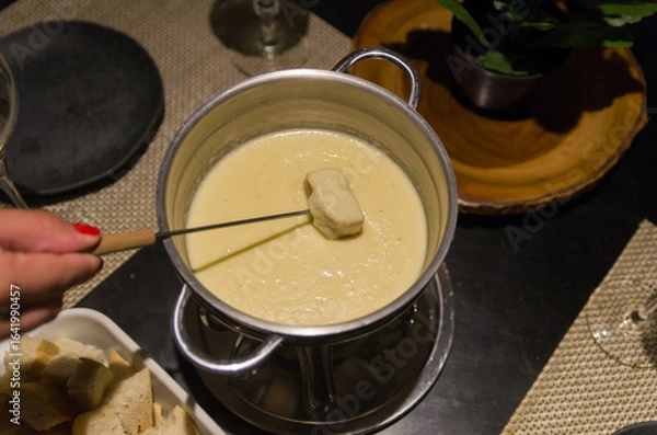 Fototapeta Traditional cheese fondue with bread and a glass of wine.