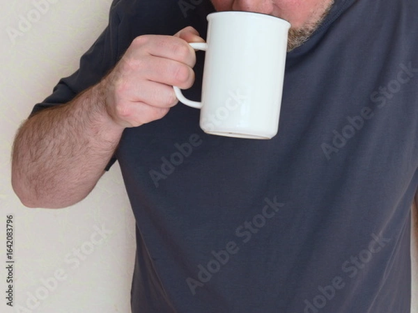 Obraz A man drinks coffee from a white cup