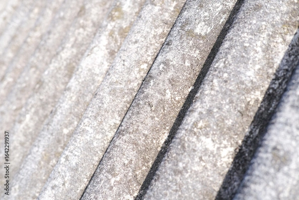 Fototapeta Close-up of shingles, slate roof. Abstract beige gray background with wavy texture. External design of the building. Roofing banner texture, background for roofing banner. Copy space