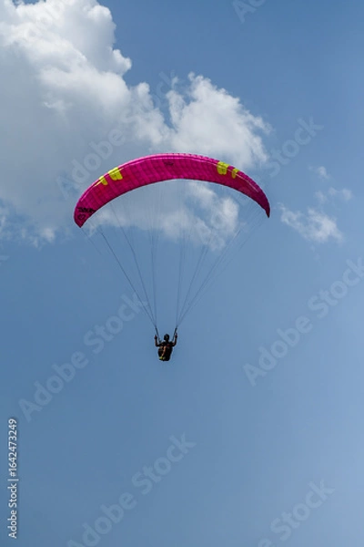 Obraz Man paragliding in the town of Organya in the province of Lleida in northern Spain in August 2025.